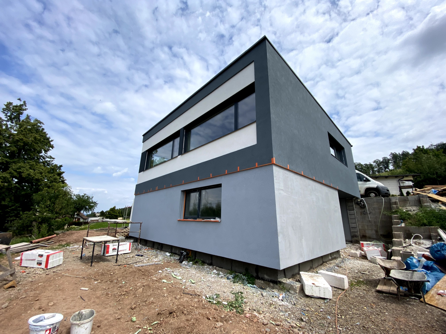 Zadní strana rodinného domu, Moderní široká okna, Bílo-šedá fasáda, dvě patra.