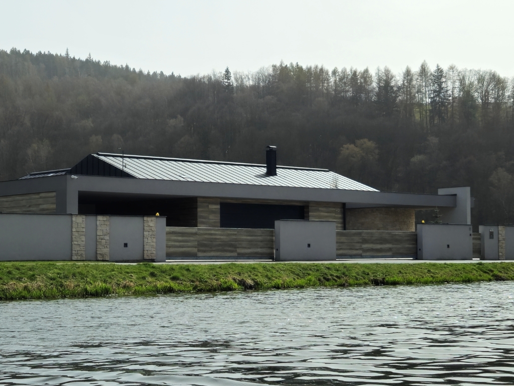 Rodinný dům Běloves Dokončená stavba rodinného moderního domu. Šedo-bílá fasáda s dřevěným detailem.