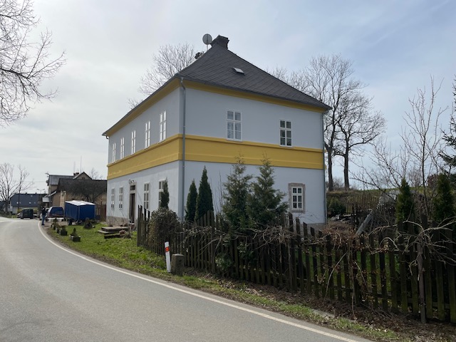 Fasáda Kohoutov Dokončená stavba rodinného moderního domu. Šedo-bílá fasáda s dřevěným detailem.
